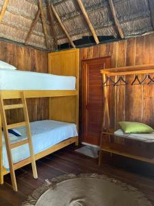 2 literas en una habitación con paredes de madera en Playa las palmas, en Tulum