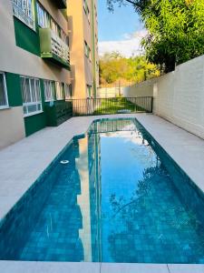 a swimming pool in front of a building at Apartamento novo zona leste. in Teresina