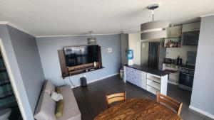 a living room with a dining room table and a tv at Departamento 3d y 2b condominio mistral oriente 2 in La Serena