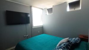 a bedroom with a bed and a flat screen tv at Departamento 3d y 2b condominio mistral oriente 2 in La Serena
