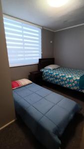 a bedroom with two beds and a large window at Departamento 3d y 2b condominio mistral oriente 2 in La Serena