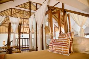 um quarto com uma cama com redes mosquiteiras brancas em Villa Sunset Beach em Gili Trawangan