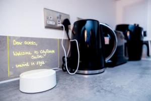 a kitchen counter with a coffee pot on a counter top at City Escape - Unwind in Style in Barking
