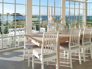 jadalnia ze stołem, krzesłami i oknami w obiekcie Holiday home Assens IV w mieście Assens
