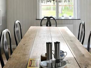 uma mesa de jantar com cadeiras e uma mesa de madeira com em Holiday home TRÖNÖDAL em Vallsta