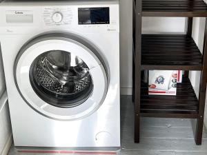 uma máquina de lavar roupa branca num quarto com uma prateleira em Holiday home TRÖNÖDAL em Vallsta