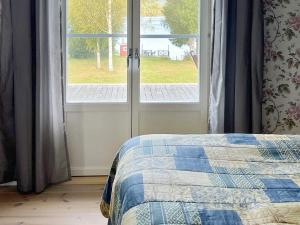a bedroom with a bed next to a window at Holiday home TRÖNÖDAL in Vallsta