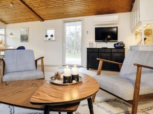 een woonkamer met een tafel en een televisie bij Holiday home Jerup LXI in Jerup