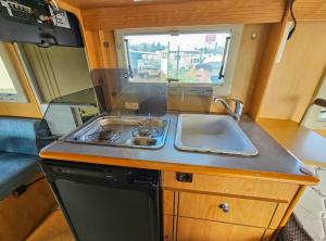 an rv kitchen with a sink and a stove at Sempre pronta para férias in Amadora