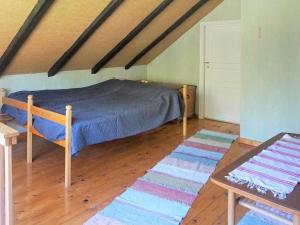 1 dormitorio con 1 cama y suelo de madera en Holiday home TINGSRYD VI en Tingsryd