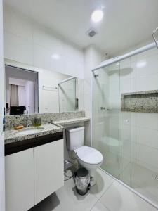 a white bathroom with a toilet and a glass shower at Apartamento novo zona leste. in Teresina