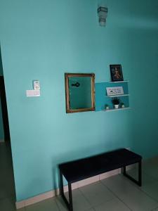 una pared azul con un banco en una habitación en MJ homestay en Nibung Tebal