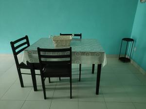 una mesa de comedor con 2 sillas y una cesta. en MJ homestay en Nibung Tebal