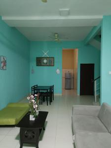 ein Wohnzimmer mit einem Sofa und einem Tisch in der Unterkunft MJ homestay in Nibung Tebal