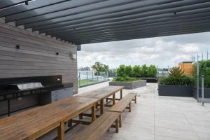 a patio with wooden benches on a roof at West End Executive Suite, on the Brisbane River. in Brisbane