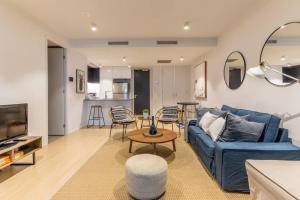 - un salon avec un canapé bleu et une table dans l'établissement West End Executive Suite, on the Brisbane River., à Brisbane