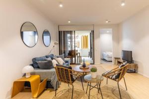 a living room with a couch and a table and chairs at West End Executive Suite, on the Brisbane River. in Brisbane