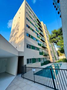 ein hohes Gebäude mit einem Zaun davor in der Unterkunft Apartamento novo zona leste. in Teresina