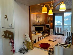 a kitchen and dining room with a table and a living room at Appartement La Clusaz, 3 pièces, 6 personnes - FR-1-437-110 in La Clusaz
