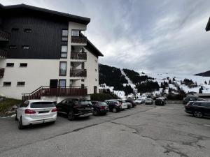 un parking avec des voitures garées devant un bâtiment dans l'établissement Appartement La Clusaz, 3 pièces, 6 personnes - FR-1-437-110, à La Clusaz