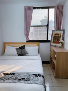 a bedroom with two beds and a large window at Chaohai Homestay in Donggang