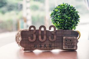 a wooden clock with a green plant in it at Chaohai Homestay in Donggang