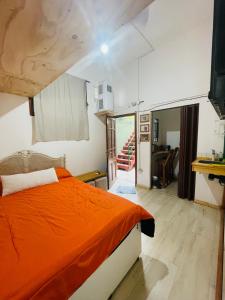 1 dormitorio con cama de color naranja y escalera en Rinconcito en Pompeya en Buenos Aires