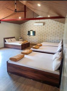 Pokój z dwoma łóżkami i telewizorem na ścianie w obiekcie Mysticstays Resort w mieście Wai
