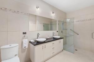 Un baño blanco con dos lavabos y una ducha. en The Lakehouse on Rosemary, en Yarrawonga 11 fotos más
