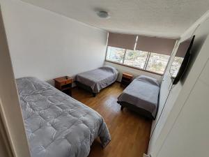 1 dormitorio con 2 camas y ventana en Amplio Departamento Central Piso 11 Frente Casino Luckia, en Arica