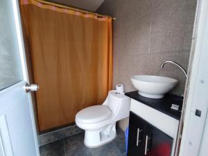 een badkamer met een wit toilet en een wastafel bij Alojamiento Familiar MariaLuisa in Quillullaco