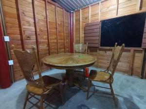ein Esszimmer mit einem Tisch und 2 Stühlen in der Unterkunft Cabaña de Madera, El Pochote in San Andrés Huayapan