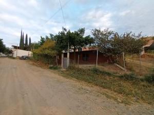 een onverharde weg met een huis aan de kant van de weg bij Cabaña de Madera, El Pochote in San Andrés Huayapan