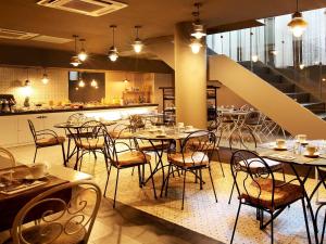 un restaurant avec des tables et des chaises et un escalier dans l'établissement Axel TWO Barcelona 4 Sup - Adults Only, à Barcelone
