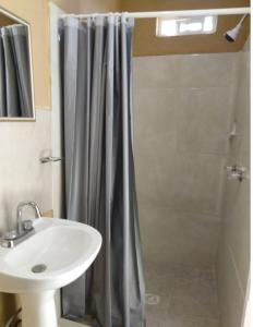 uma casa de banho com uma cortina de chuveiro e um lavatório em Posada San Carlos em San Carlos