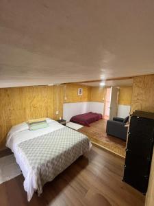 um quarto com uma cama grande e um sofá em Cabaña EL VIEJO SAM em Curaco de Velez