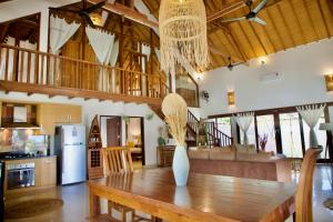 Una cocina y un comedor con una mesa de madera. en Villa Sunset Beach, en Gili Trawangan