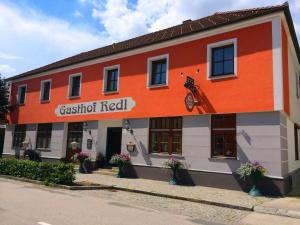 ein orangefarbenes und weißes Gebäude mit einem Motorrad drauf in der Unterkunft Gasthof Redl in 