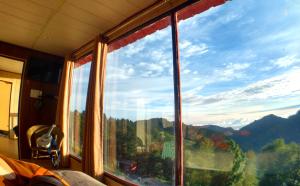 a window with a view of a mountain view at Sadhoo Vibes Resort in Dhanaulti