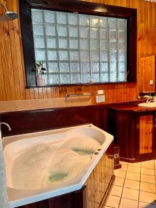 baño con bañera grande y ventana en Rustic Retreat Esperance en Esperance