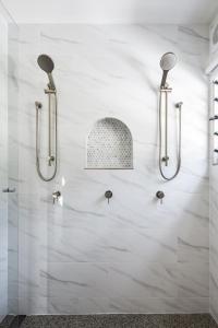 Baño blanco con 3 sistemas de ducha en la pared en Barrel View Luxury Cabins, en Ballandean