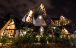 a large house with a lot of windows at night at Bach Place Dalat in Da Lat
