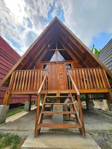ein Haus mit einem Holzdach mit zwei Holzbänken in der Unterkunft Luxury Wooden House in Kebumen + 12 Fotos