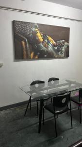 a table and chairs in a room with a painting at W District hostel in Bangkok