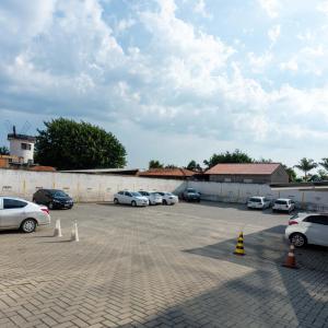 eine Gruppe von Autos, die auf einem Parkplatz geparkt sind in der Unterkunft OK Inn Hotel in Tubarão