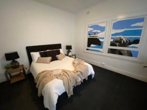 Un dormitorio con una cama grande y una ventana en Two Cow Cottage Bed & Breakfast en Keith