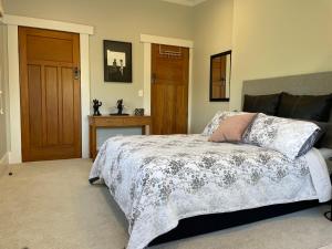 a bedroom with a bed and a wooden door at Kowhai Studio in Paeroa