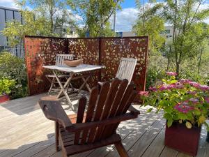 twee stoelen en een tafel op een terras met bloemen bij Kowhai Studio in Paeroa