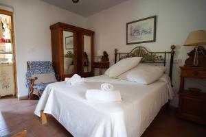 a bedroom with a bed with two towels on it at Cortijo Torreblanca in El Pozo de los Frailes