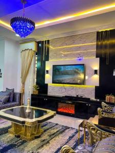 a living room with a fireplace and a tv at Luxury Charming 5Bed Duplex With Starlink wifi - Lekki in Ikota